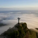 High angle view of colossal Christ Redeemer statue surrounded by clouds, Corcovado, Rio de Janeiro,