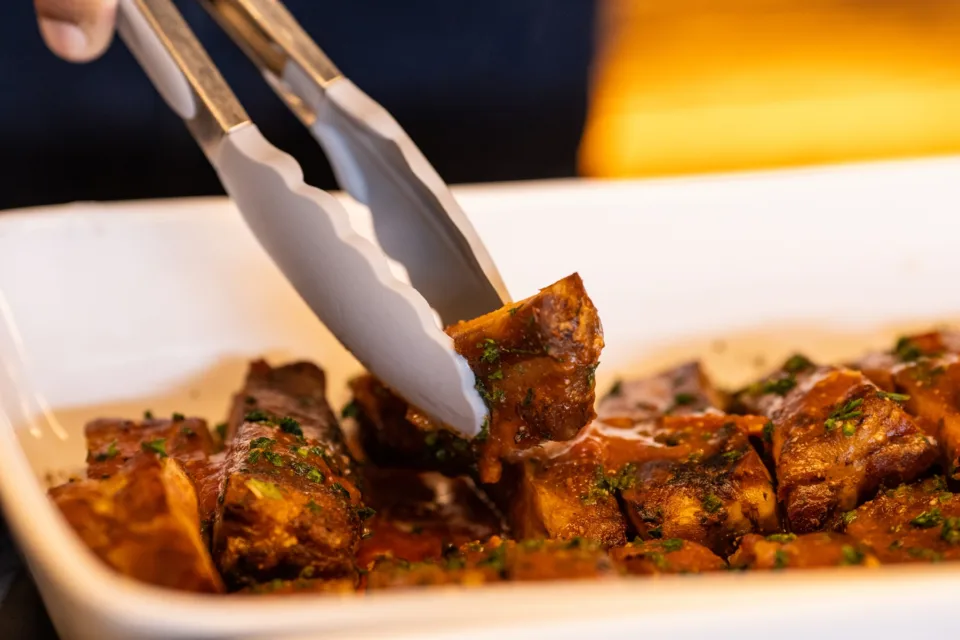 Travessa branca com cortes de carne assada lentamente e salpicados de ervas frescas, prato principal do almoco de Dia dos Pais no restaurante Brisa Resto, no Lagune Barra Hotel, na Barra Olimpica