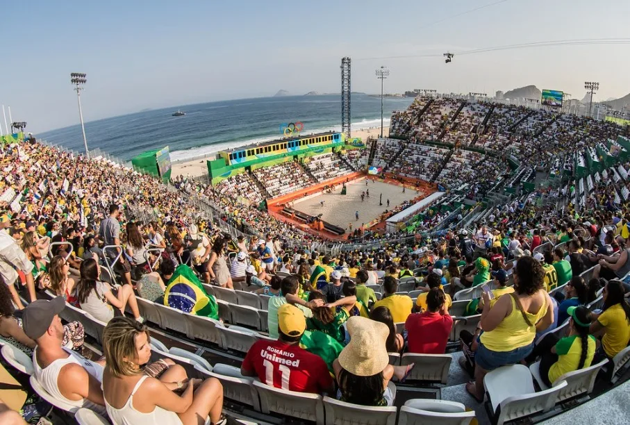 Arena de vôlei de praia montada na orla de Copacabana, no Rio de Janeiro, com arquibancadas lotadas durante competição