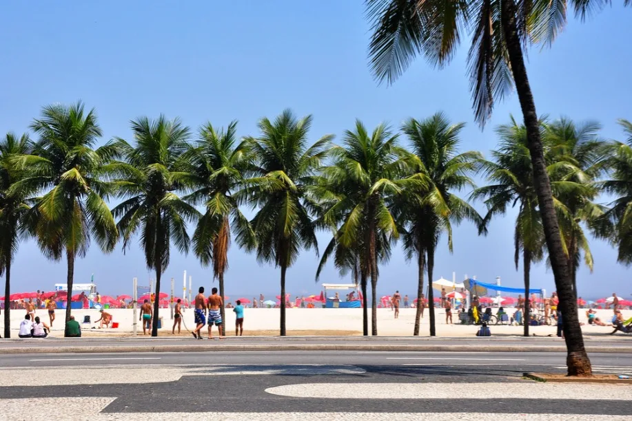 Orla de Copacabana, no Rio de Janeiro, com quiosques e movimento de banhistas no calçadão