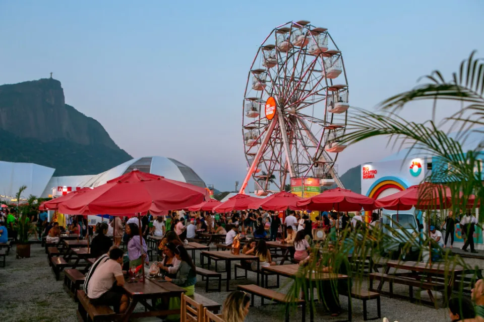 Público circula entre estandes de restaurantes iluminados durante o festival Rio Gastronomia, no Jockey Club Brasileiro, na Gávea, Rio de Janeiro