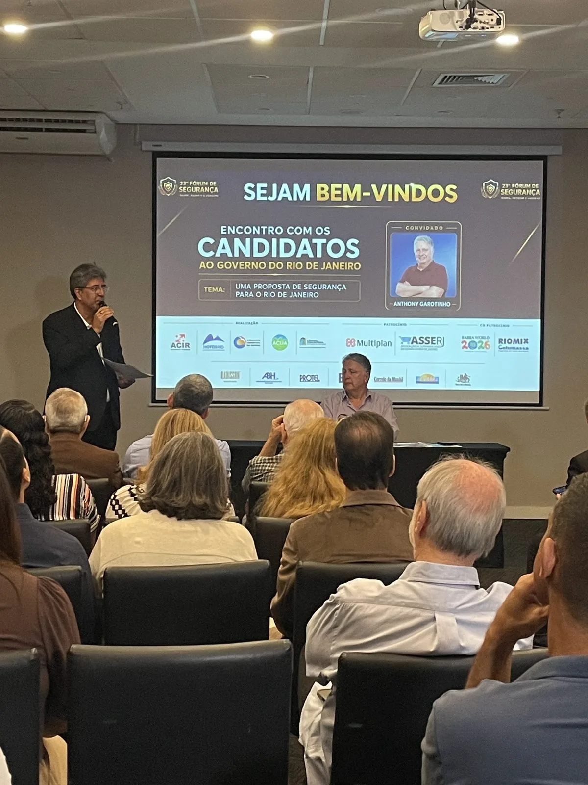 Dirigente do HotéisRIO fala ao público na abertura do encontro com candidatos ao governo do RJ