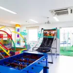 Espaço kids do CDesign Hotel com piscina de bolinhas, pebolim e jogo de basquete