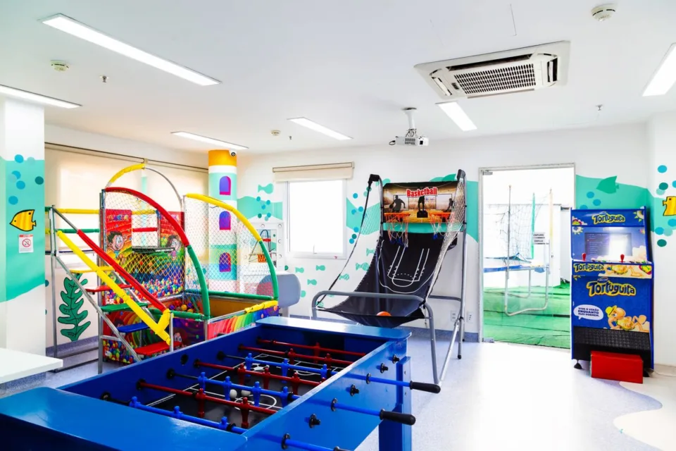 Espaço kids do CDesign Hotel com piscina de bolinhas, pebolim e jogo de basquete