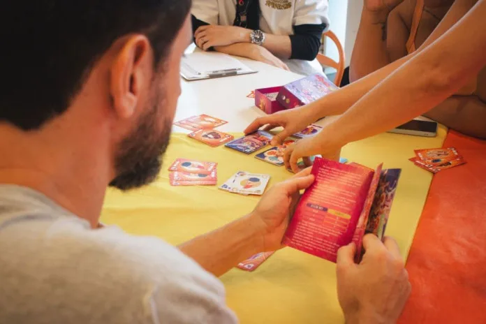 Participantes em mesa de jogos de tabuleiro no encontro Diversidade em Jogo, no Museu de Arte do Rio