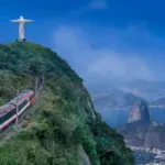 Composição do Trem do Corcovado subindo a serra em meio à mata, no Rio de Janeiro