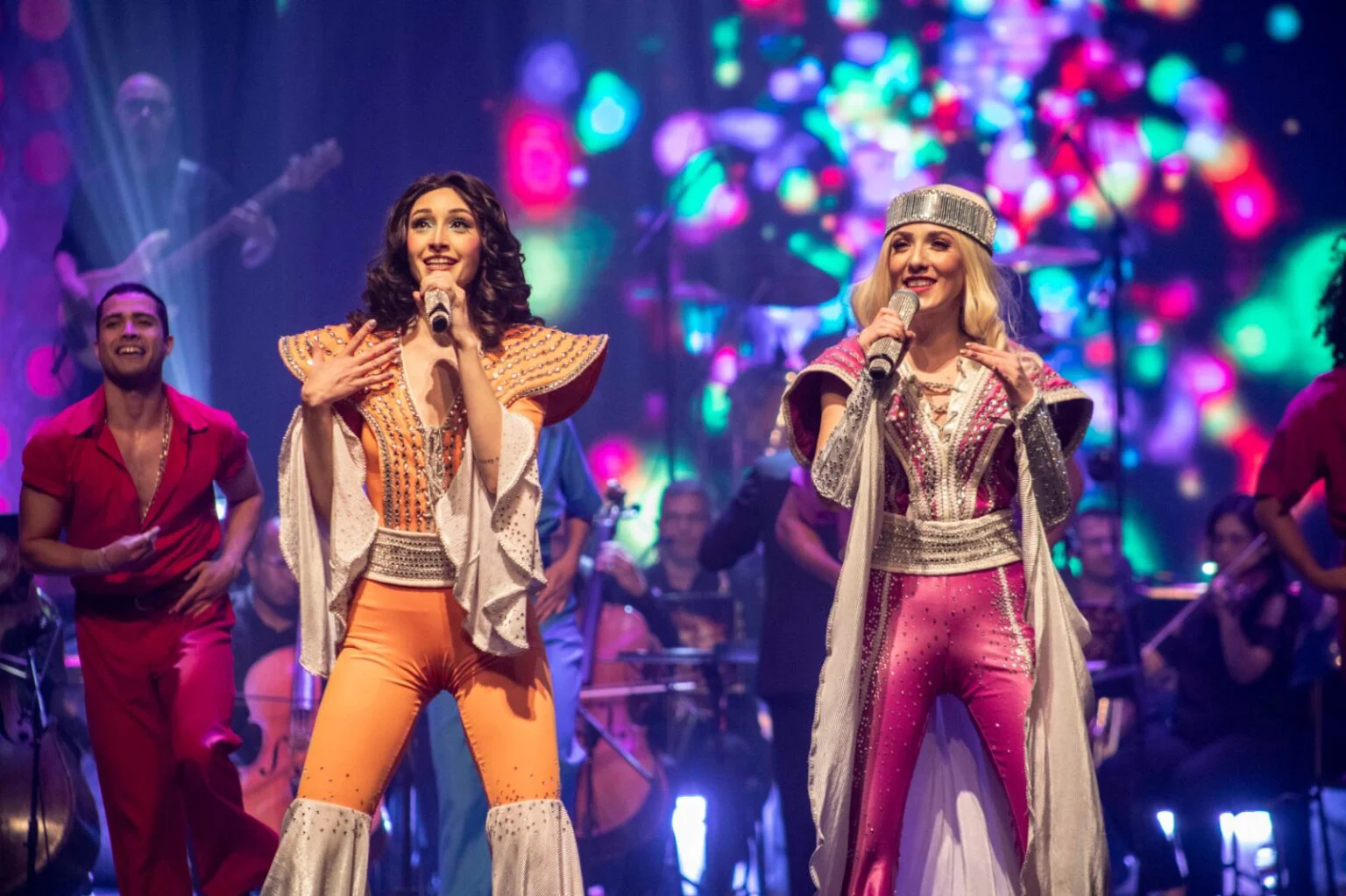 Cantoras do espetáculo Abba Experience no palco com figurinos da era disco
