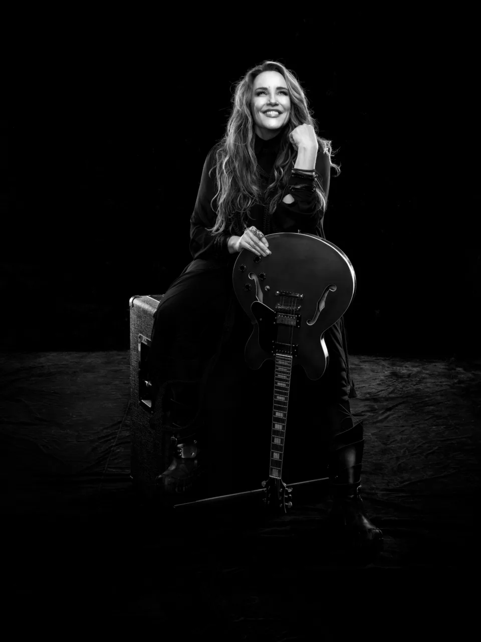 Ana Carolina sentada com guitarra em foto de divulgação da turnê 25 Anas