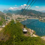 Bondinho do Pão de Açúcar em funcionamento com a paisagem da Baía de Guanabara ao fundo