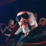 Arte de divulgação do SulAmérica Sessions com Carlinhos Brown de óculos escuros e músicos da Orquestra Ouro Preto ao fundo