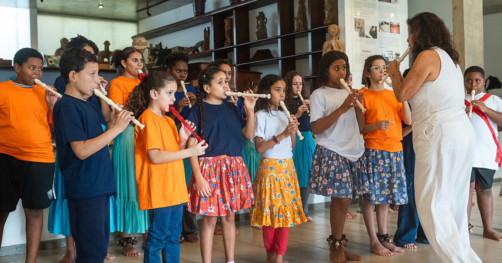 Crianças do projeto Flautistas da Marambaia tocam flauta doce no Museu do Pontal