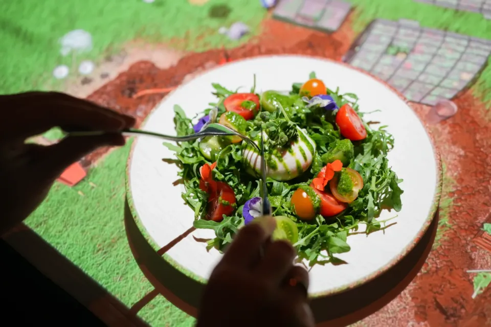 Prato servido sobre mesa com projeção 3D da experiência Le Petit Chef