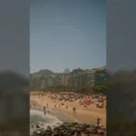 Vista da praia do Leme e de Copacabana com banhistas na areia, perto do Novotel Leme