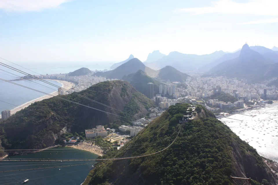 Vista do alto do Pão de Açúcar com a Praia de Copacabana, o Morro da Urca, a Enseada de Botafogo e o Cristo Redentor ao fundo, no Rio de Janeiro