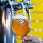 Público em festival de cerveja artesanal ao ar livre na Praça Central do Downtown, na Barra da Tijuca, Rio de Janeiro