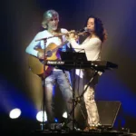 Oswaldo Montenegro toca violão ao lado da flautista Madalena Salles no palco