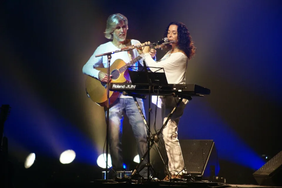 Oswaldo Montenegro toca violão ao lado da flautista Madalena Salles no palco