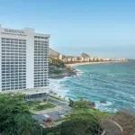Fachada do Sheraton Grand Rio Hotel & Resort, na Avenida Niemeyer, com a orla do Leblon e de Ipanema ao fundo