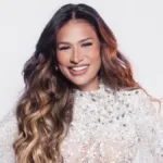 Retrato da cantora Simone Mendes sorrindo, com vestido brilhante