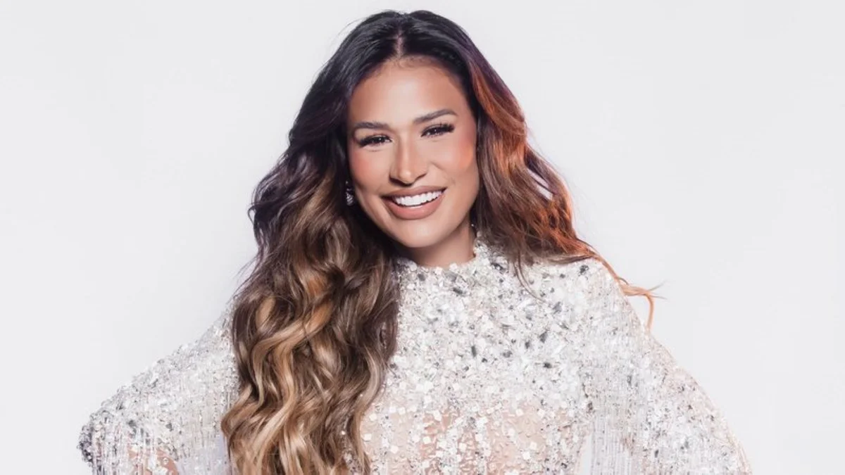 Retrato da cantora Simone Mendes sorrindo, com vestido brilhante